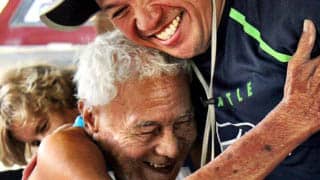 A caregiver hugs a Vietnamese recipient of the Free Wheelchair Mission.