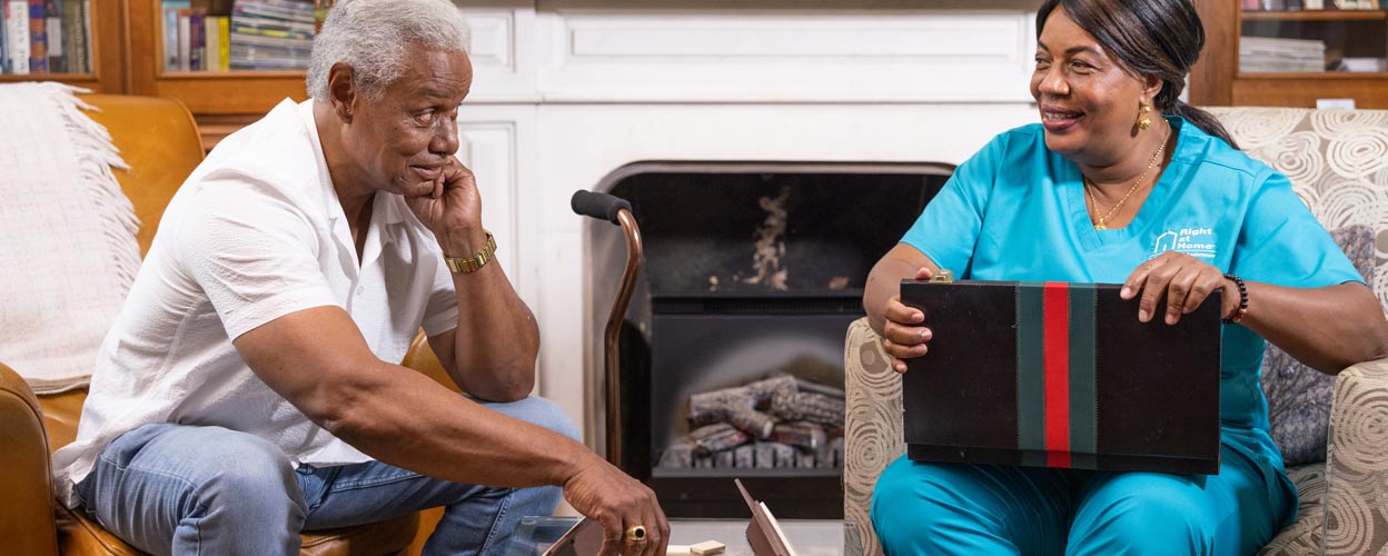 A caregiver with a mask does medication management for his client.