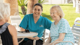 Female caregiver on the phone, smiling.